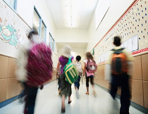 students walking down hallway of school