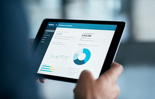 Gros plan d’un entrepreneur analysant des statistiques sur une tablette numérique dans un bureau 