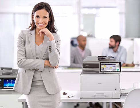 Woman in office and grey suit with multiple RICOH printers
