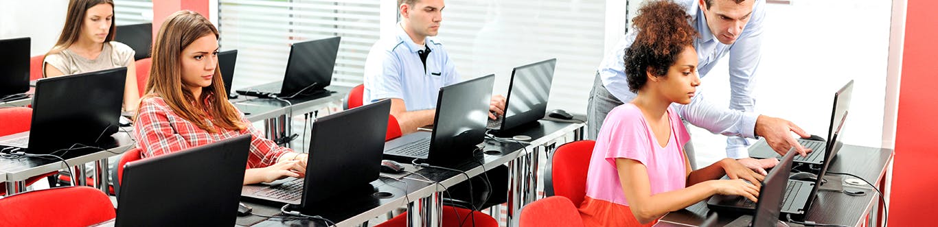 Students working on computers in a red room