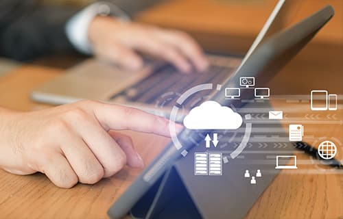 close up on businessman hand working on laptop and tablet screen to synchronize to cloud backup