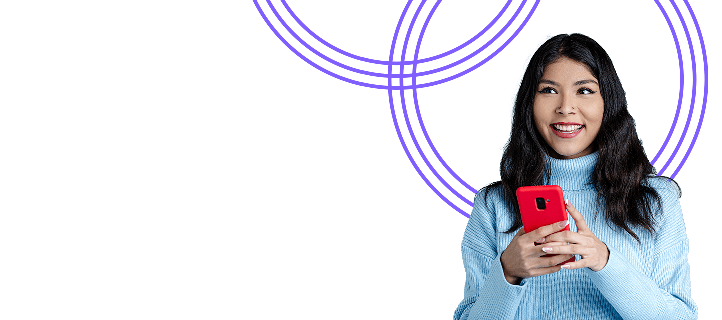 A woman smiling with a phone in her hands.