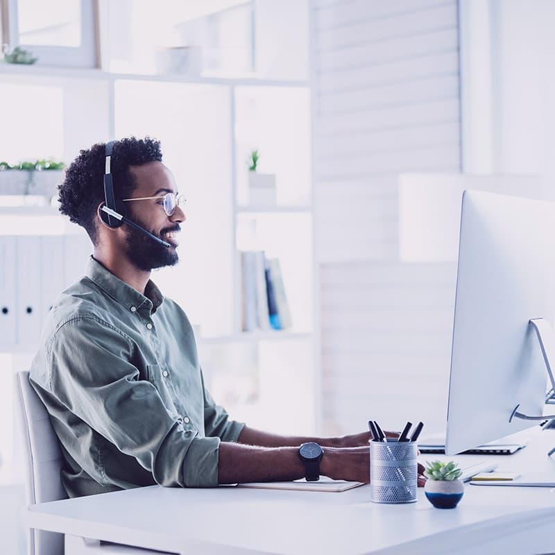 Shot of a young call centre agent working on a computer in an office