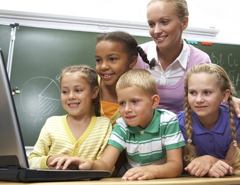 Group of children and teacher using laptop computer.