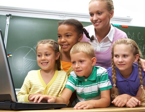 Group of children and teacher using laptop computer.