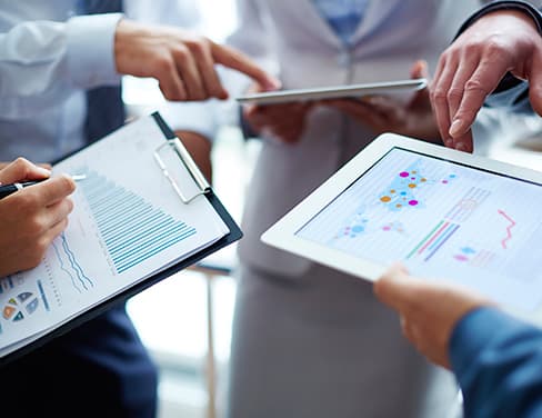 Closeup of three people's hands holding tablets