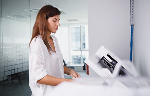 Employé utilisant une imprimante dans un environnement de bureau