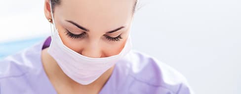 Female dentist wearing face mask.