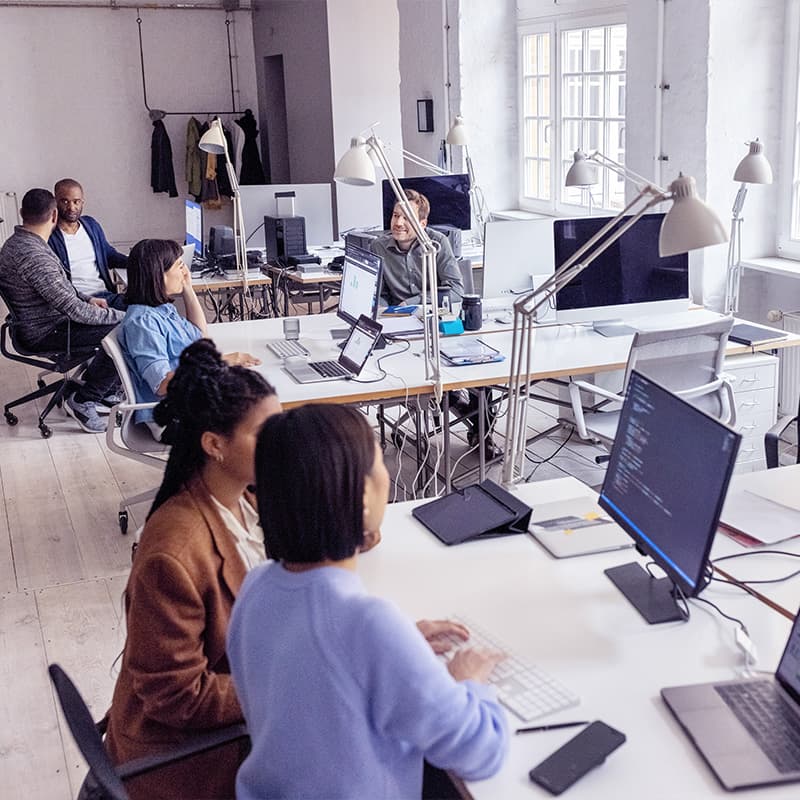 Employees working around the office on laptops and tablets