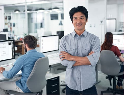 Professional man standing in office, smiling because of his new enterprise content management system