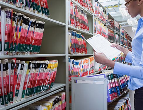 Professional woman sorting files in a file rack