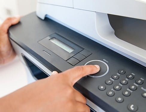 Close up of hands operating printer.