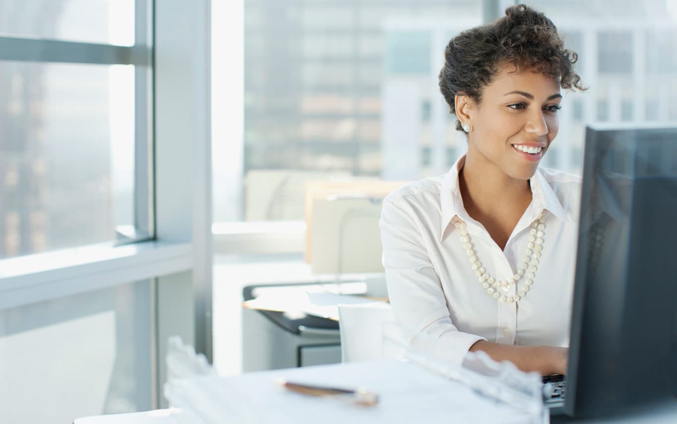 femme souriante devant un ordinateur