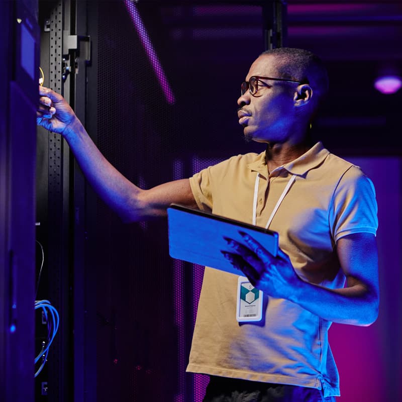Man working in a server room with tablet