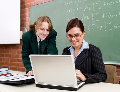 Teacher and a student working on a laptop