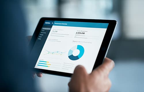 Gros plan d’un entrepreneur analysant des statistiques sur une tablette numérique dans un bureau