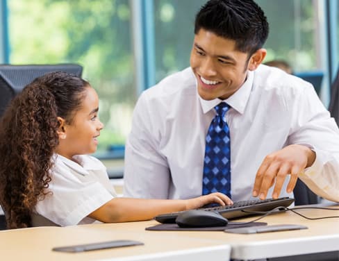Asian teacher and african american child in classroom.