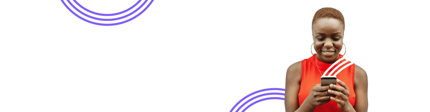 Femme vêtue d’une chemise orange qui regarde son téléphone mobile